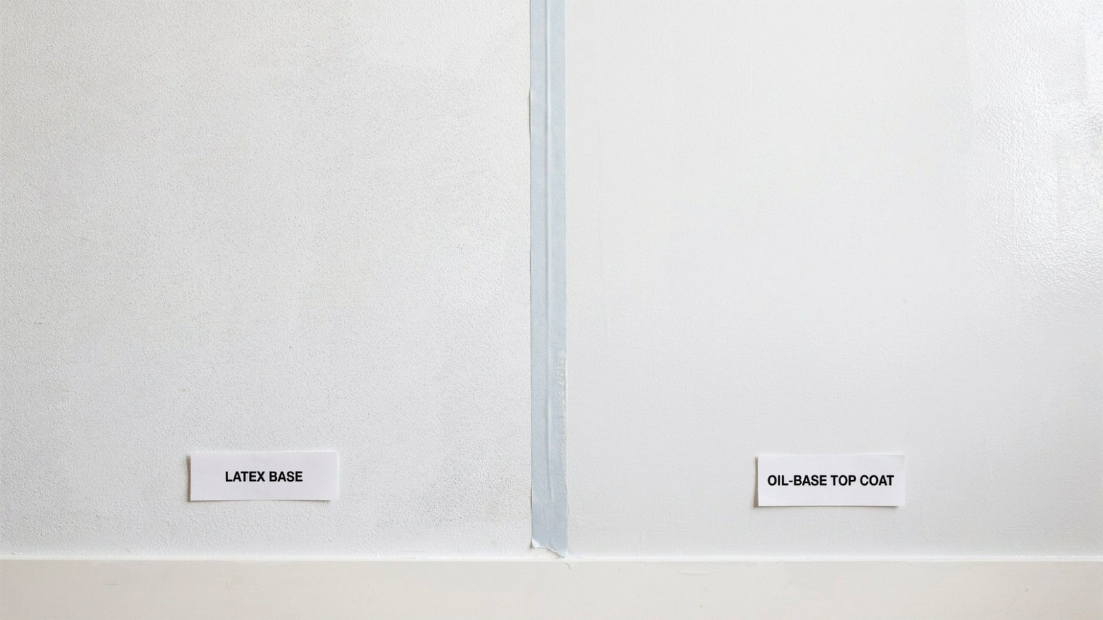Wall showing latex base layer and oil based paint applied on top with smooth finish and clean indoor surface.