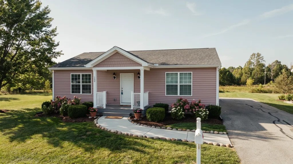 Dusty rose mobile home with warm white trim creating a soft cottage-inspired exterior.