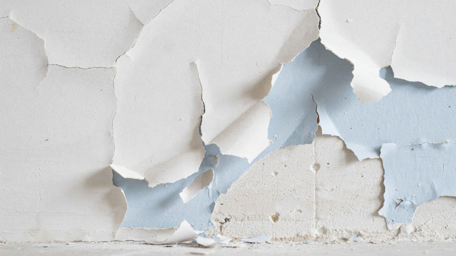 Wall with peeling chipped and flaking paint layers showing damaged surface unsuitable for applying new oil based paint.