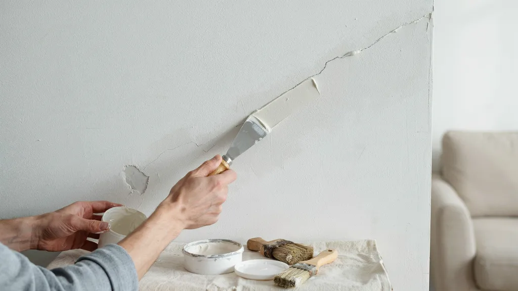 Repairing wall cracks and holes before blending new paint with old paint.