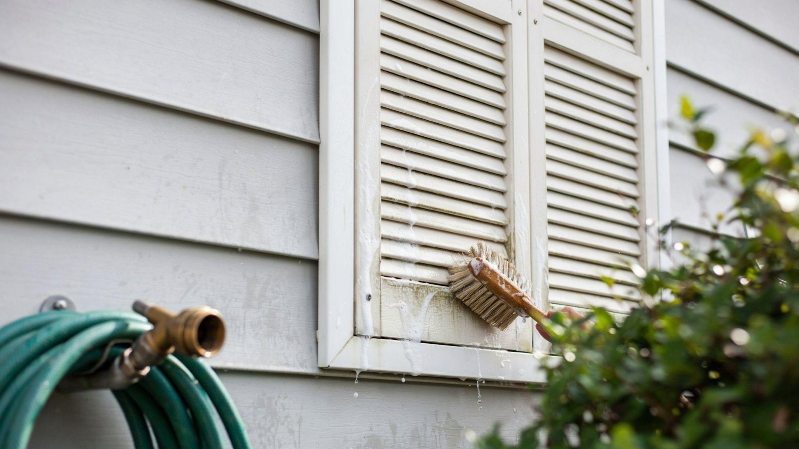 House shutters being cleaned to remove dirt, dust, and mildew before painting.