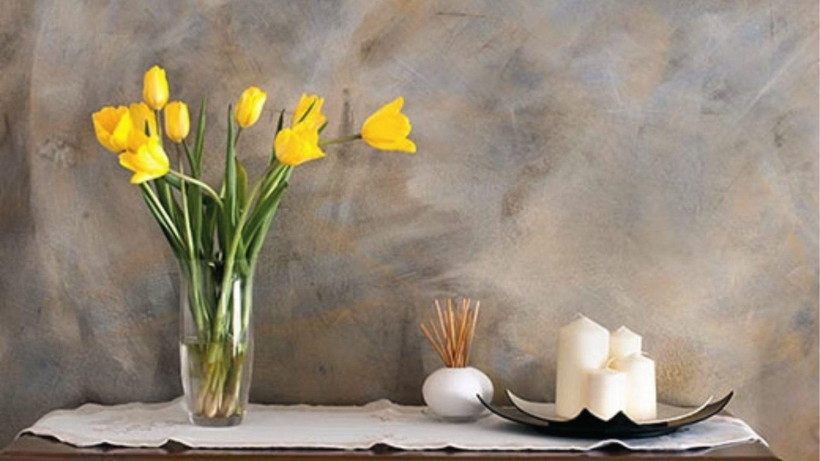 Mottled gray faux stone wall behind tulips and candles, suede or color wash finish