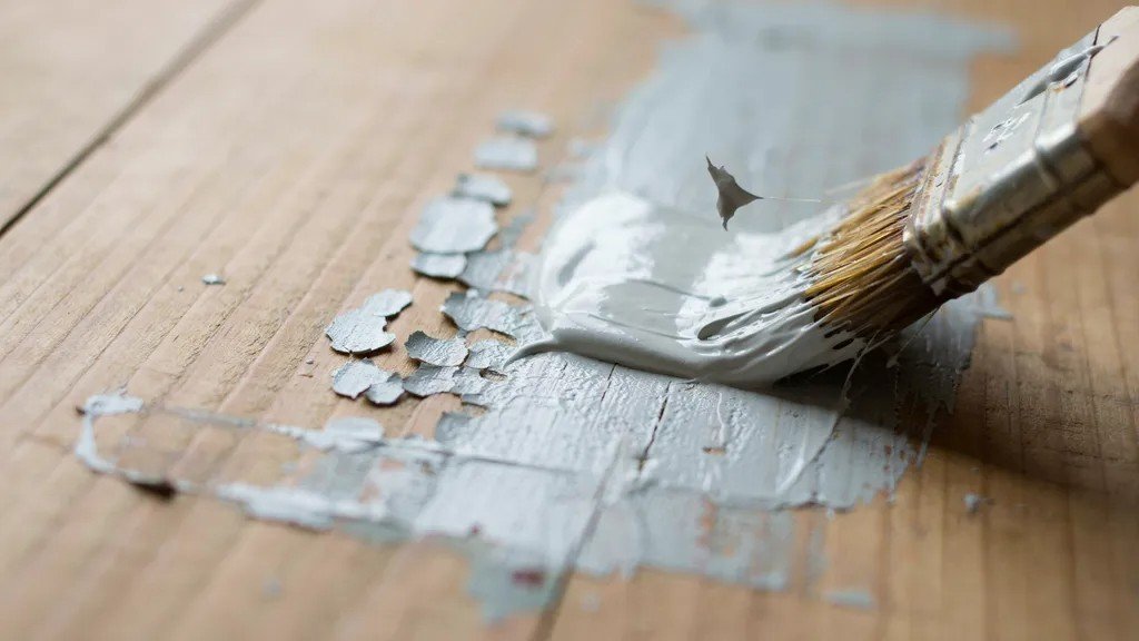 Applying paint stripper evenly onto a painted surface