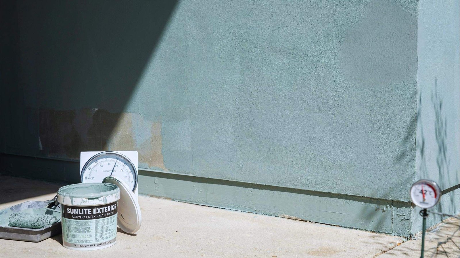 Exterior paint drying affected by sunlight humidity and temperature variations shown on wall surface in outdoor environment.