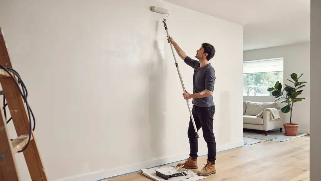 Applying water-based paint over oil-based primer with a roller.