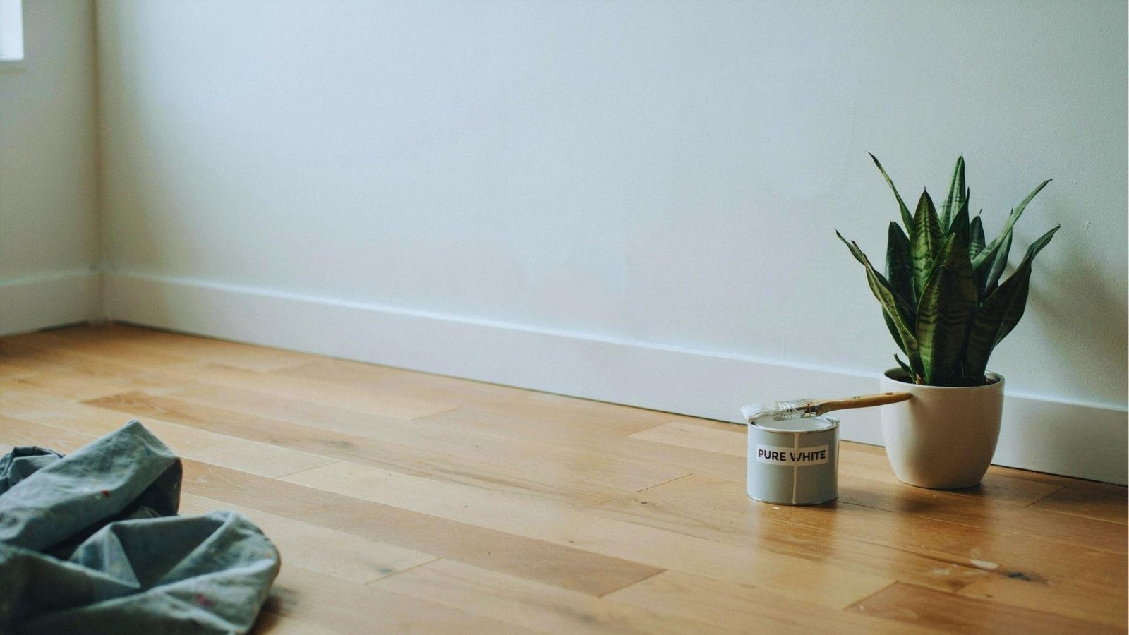 Smooth white baseboards with glossy finish and clean edges along the wall and floor in a bright interior setting.