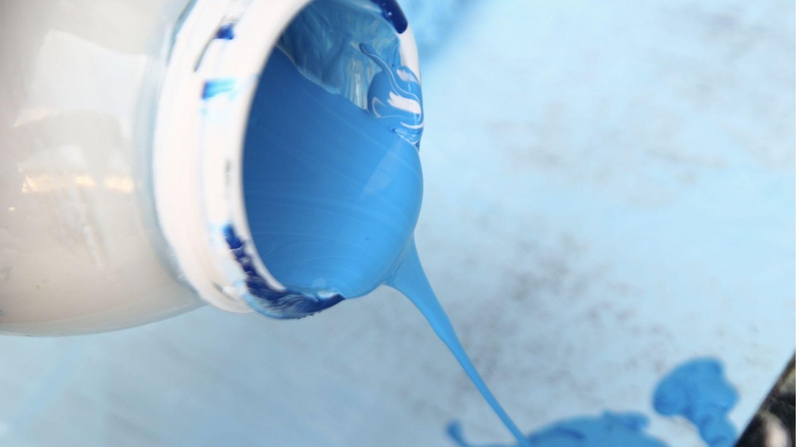 Blue elastomeric paint pours from the can, thick consistency is a drawback needing multiple coats.