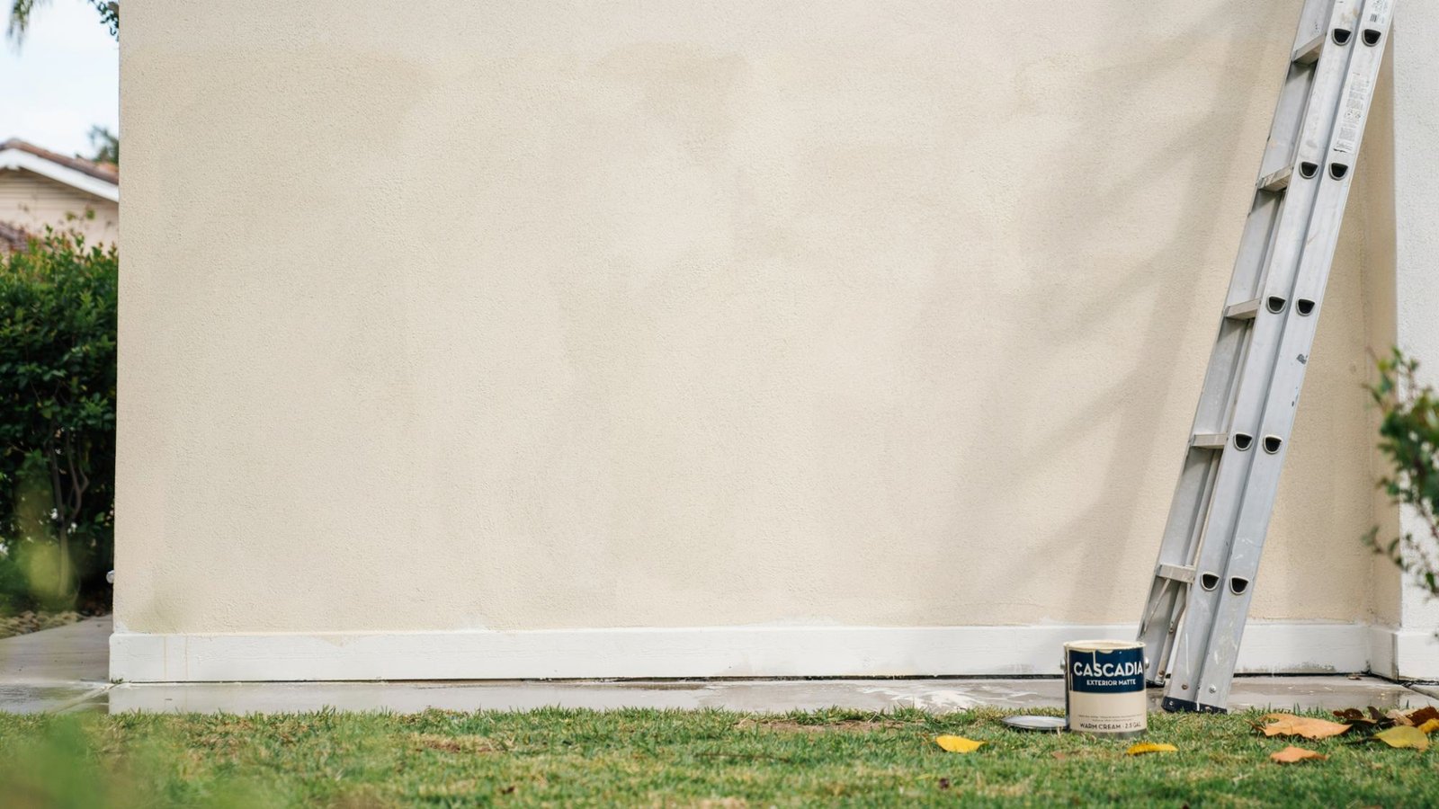 Freshly painted exterior house wall drying evenly under daylight with smooth finish and clean residential outdoor setting visible.